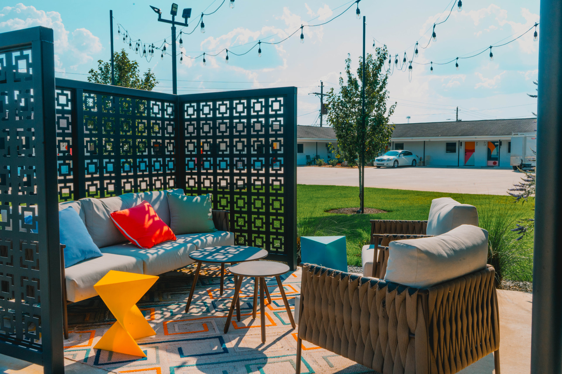 Outdoor lounge patio with string lights and breeze-block screens