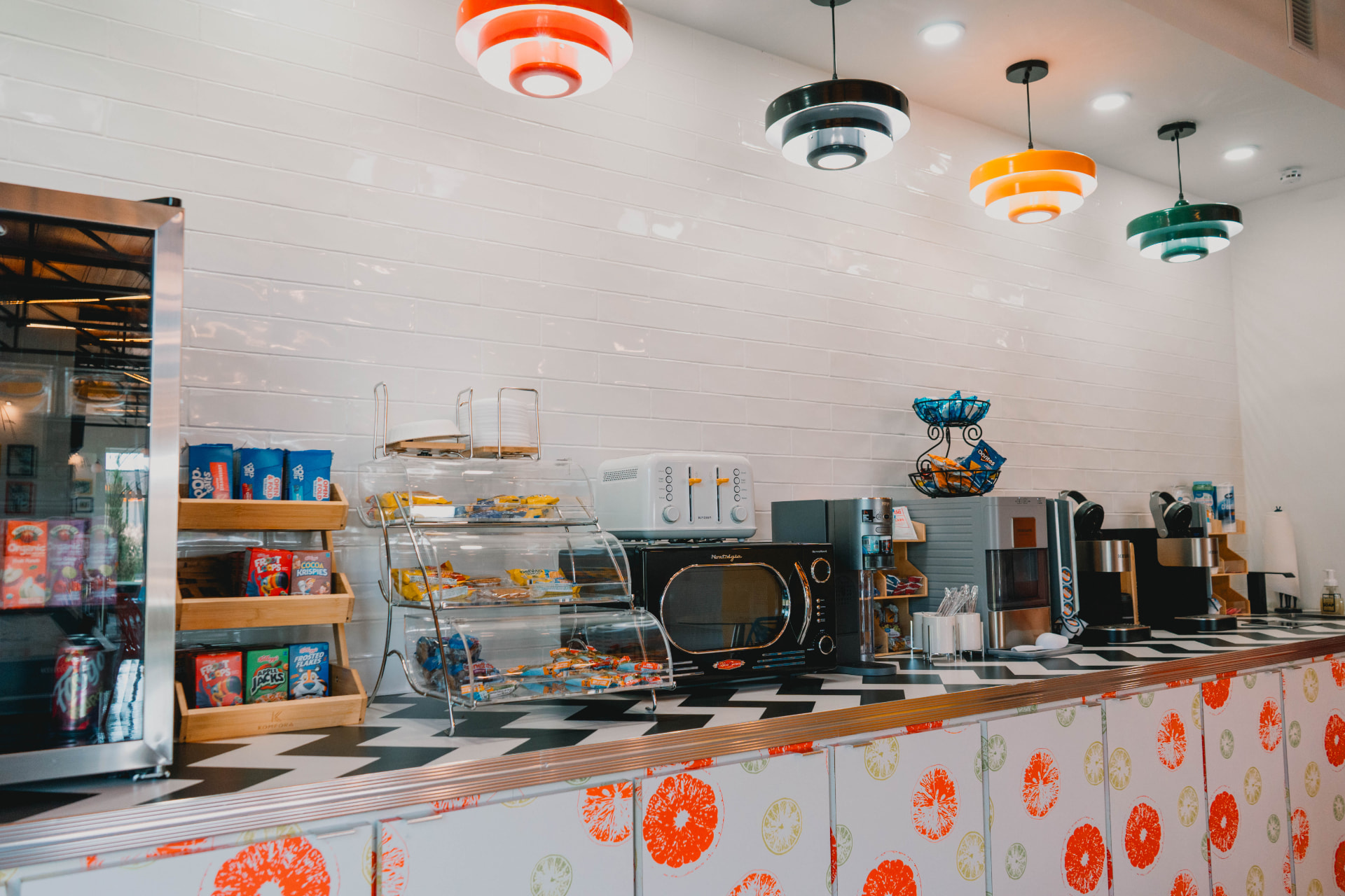 The Riviera coffee bar with a checkered counter, snacks, and retro pendant lamps